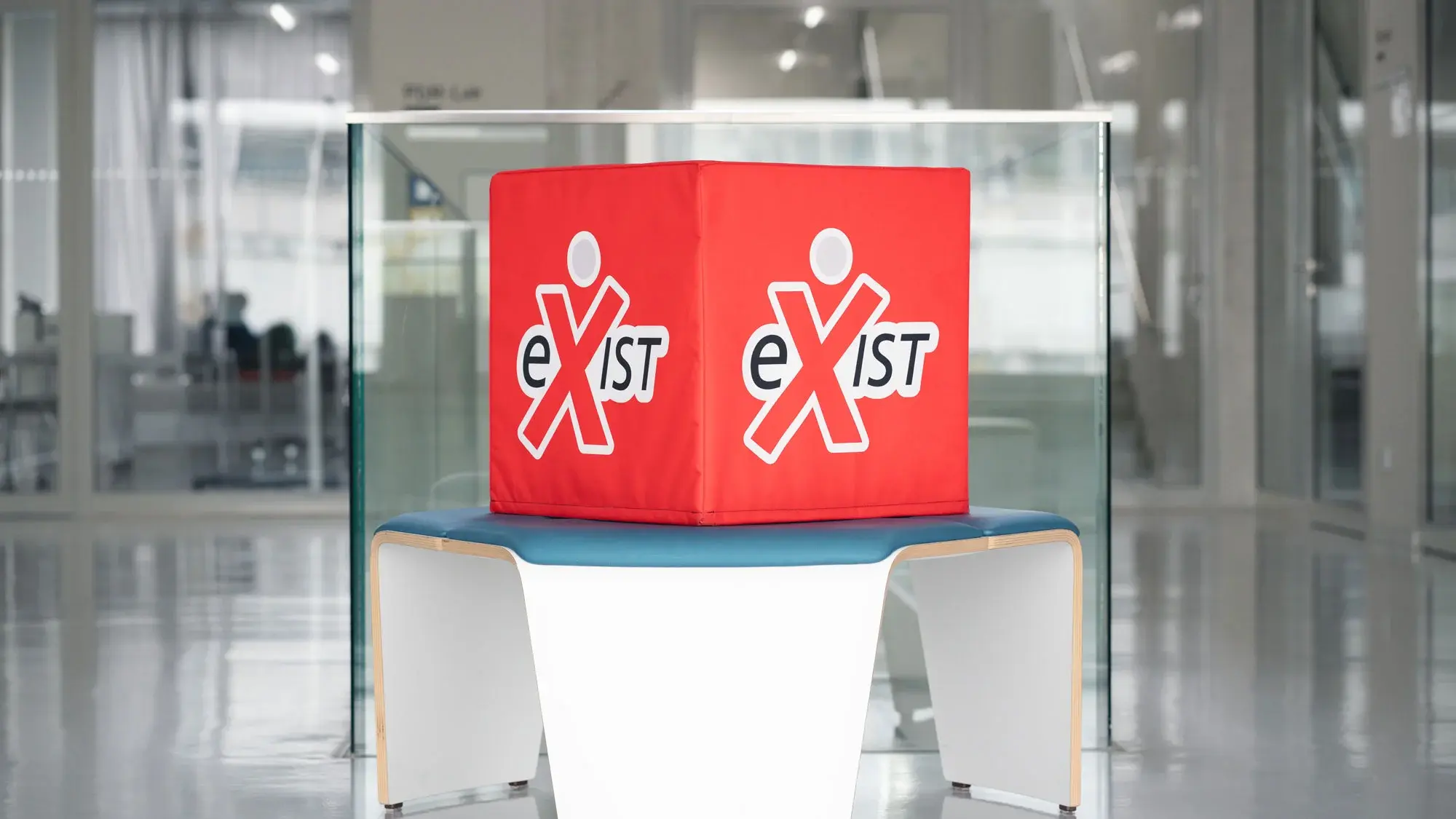 Ein roter Sitzwürfel mit dem Logo des Förderpogramms EXIST steht im Gebäude der HdM