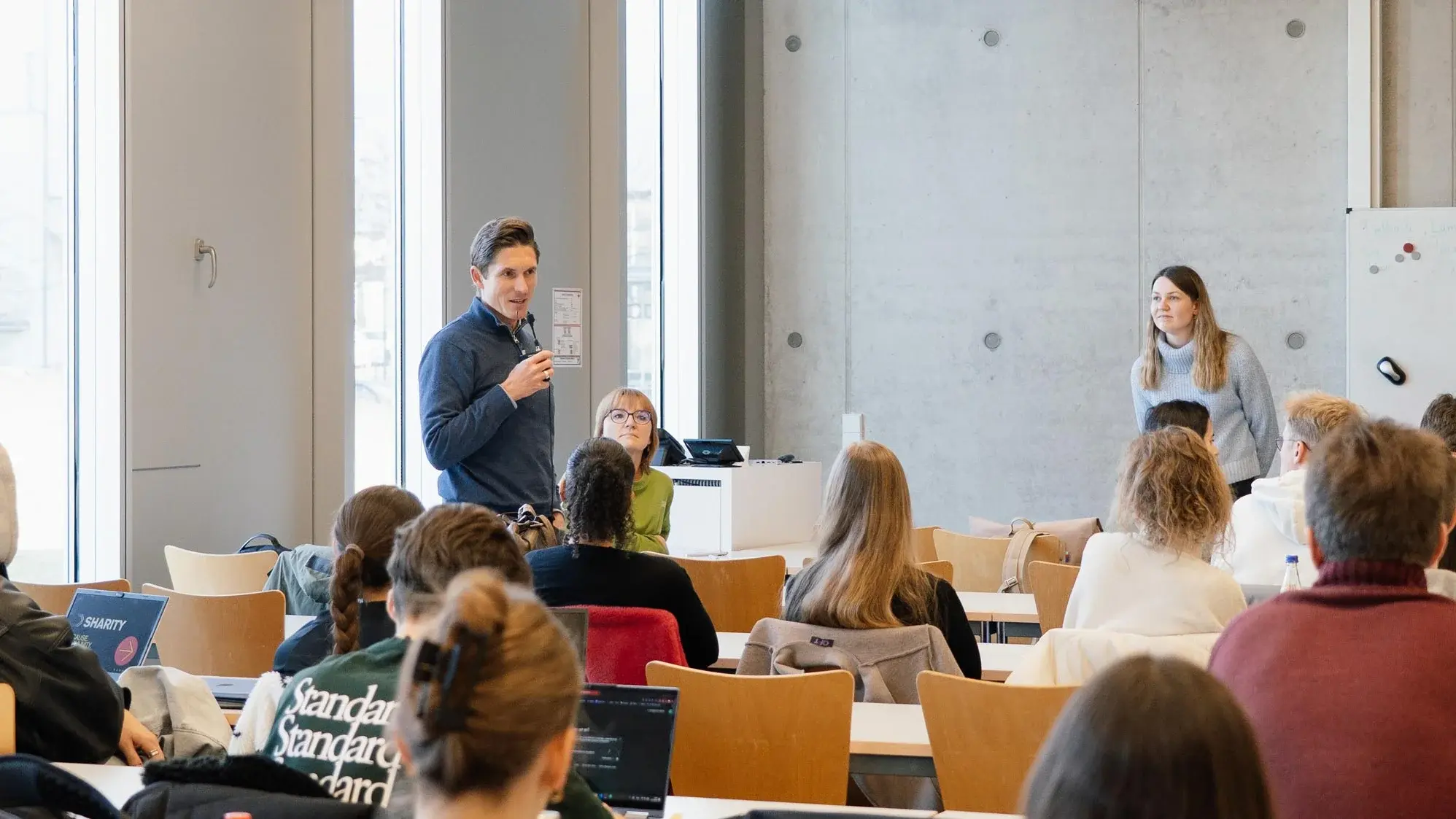 Dieses Foto zeigt einen Speaker, der im Publikum steht und sich vorstellt.