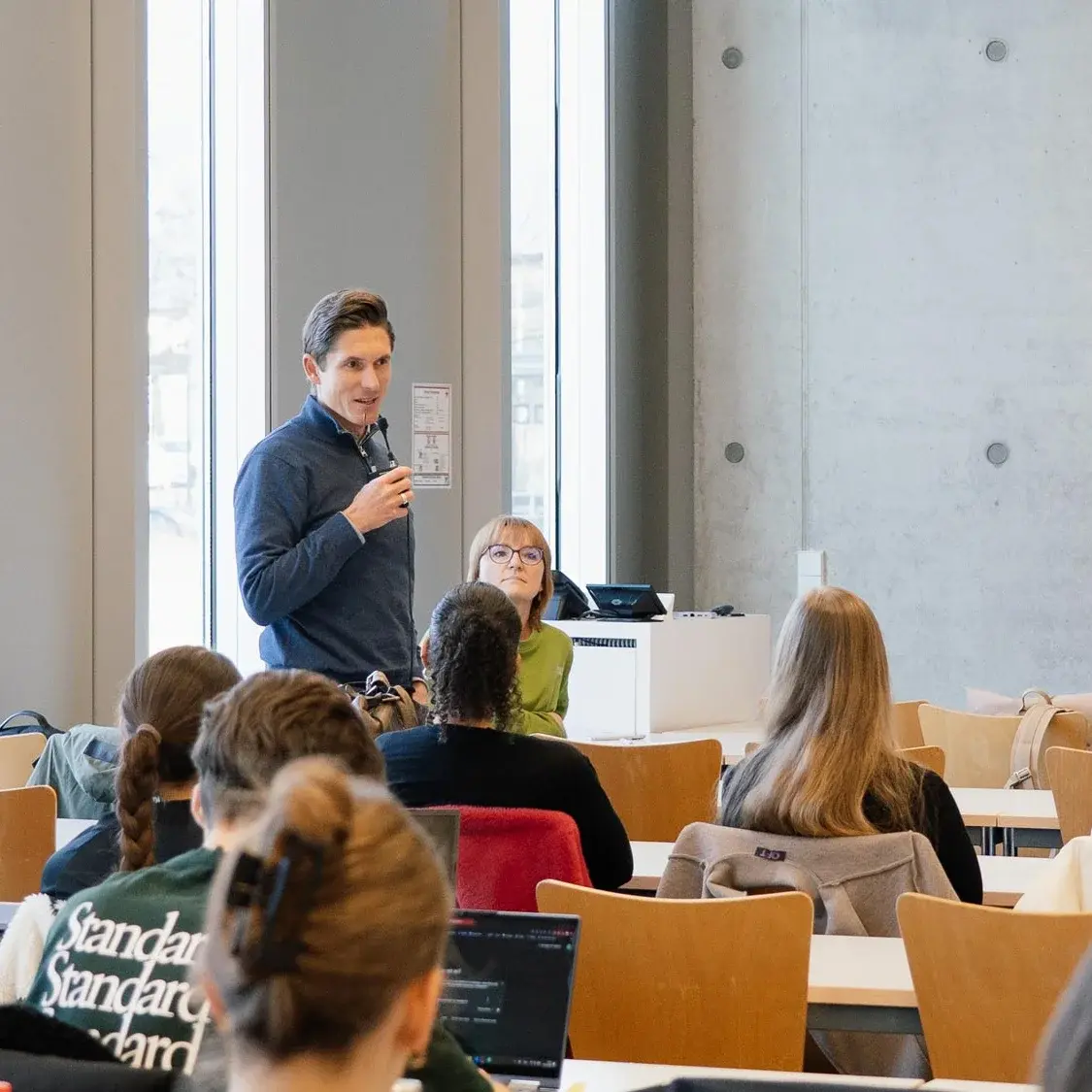 Dieses Foto zeigt einen Speaker, der im Publikum steht und sich vorstellt.